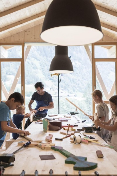 Kleine Kinder basteln mit Betreuer in der Werkstatt