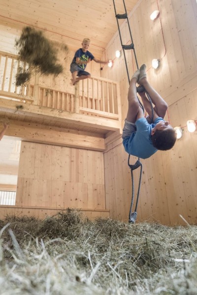 3 Jungs spielen in der Spiele-Scheune im Heu