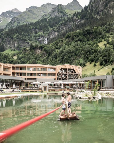 2 Jungs ziehen sich auf dem Floß über den Teich