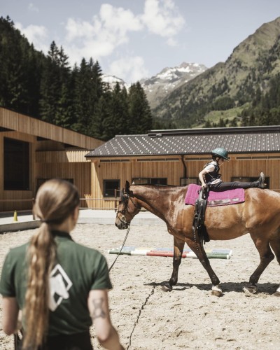 Reitschülerin praktiziert bÜbungen auf Pferd