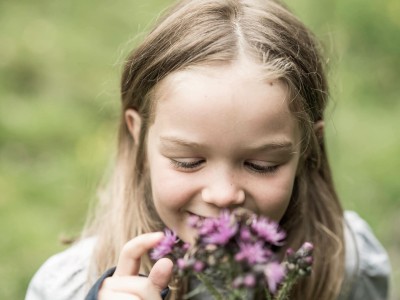 Mädchen riecht an Blumen