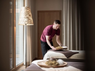 Massage-Mitarbetier präpariert die Liege