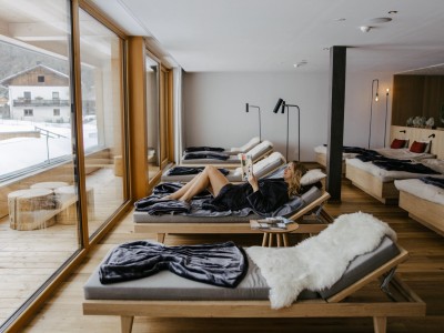 Frau ließt Buch auf einer Liege im Ruheraum