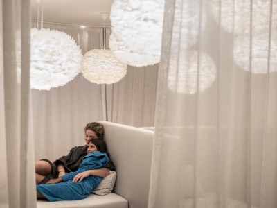 Mutter und Tochter liegen entspannt beieinander, beide in einem Bademantel eingewickelt