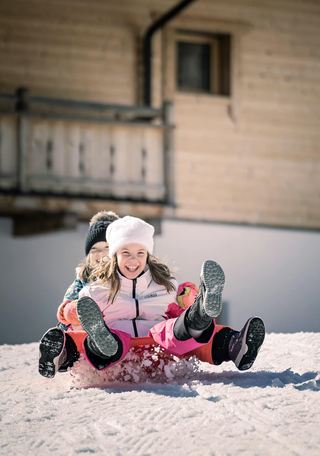 Kinder rodeln den Hügel hinunter
