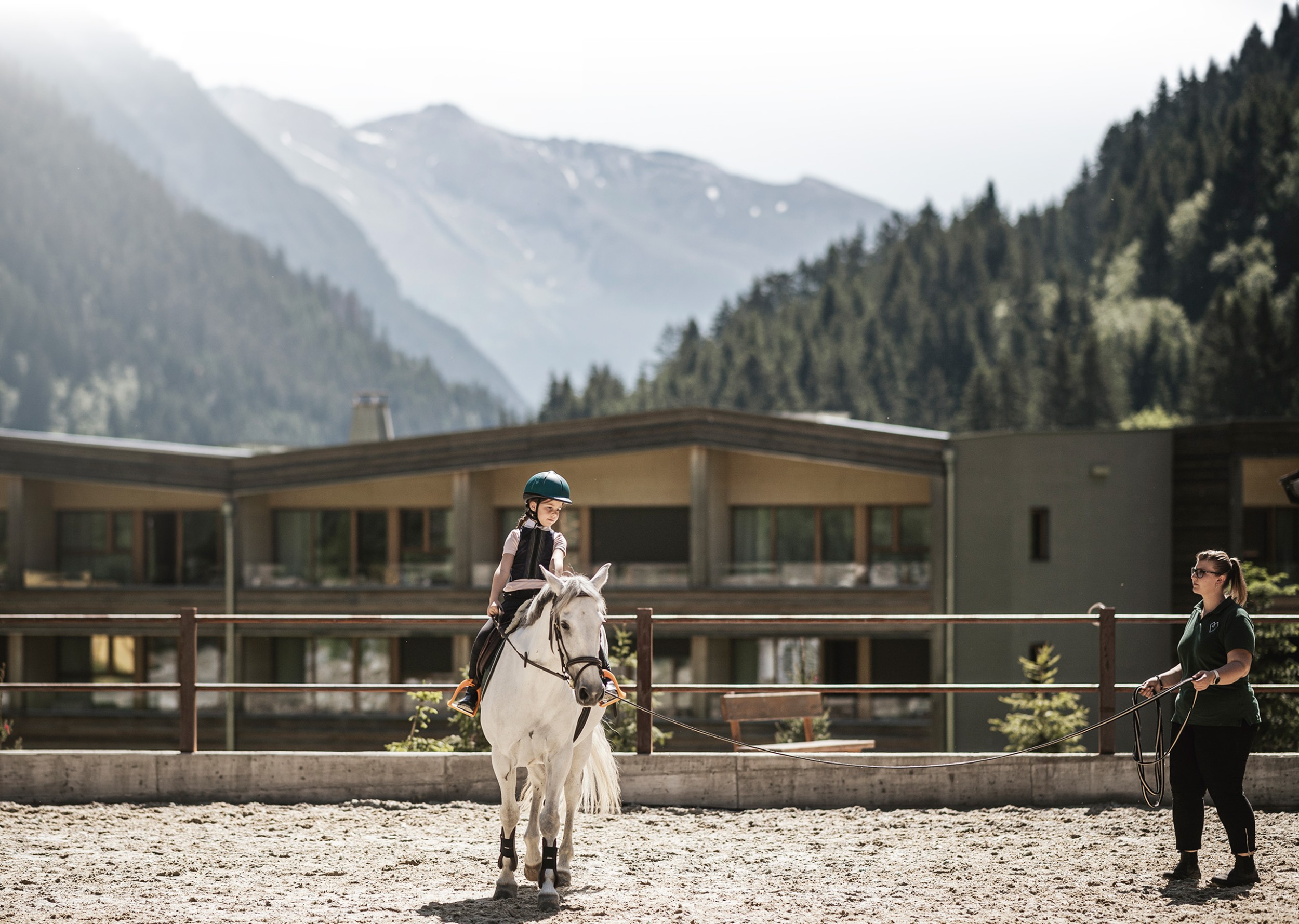 Pferdelehrerin mit Kind auf Pferd reiten am Reiterhof