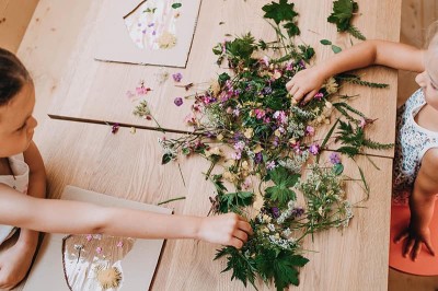Kinder spielen mit Kreuter auf einem Tisch