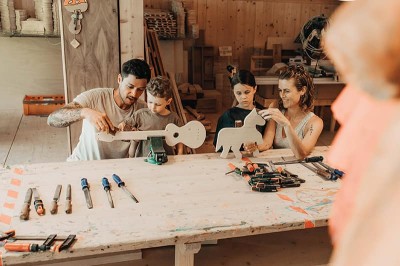 Kinder spielen in der Werkstatt und basteln eine Gitarre