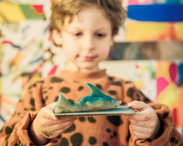 Kind bastelt kleinen Hai