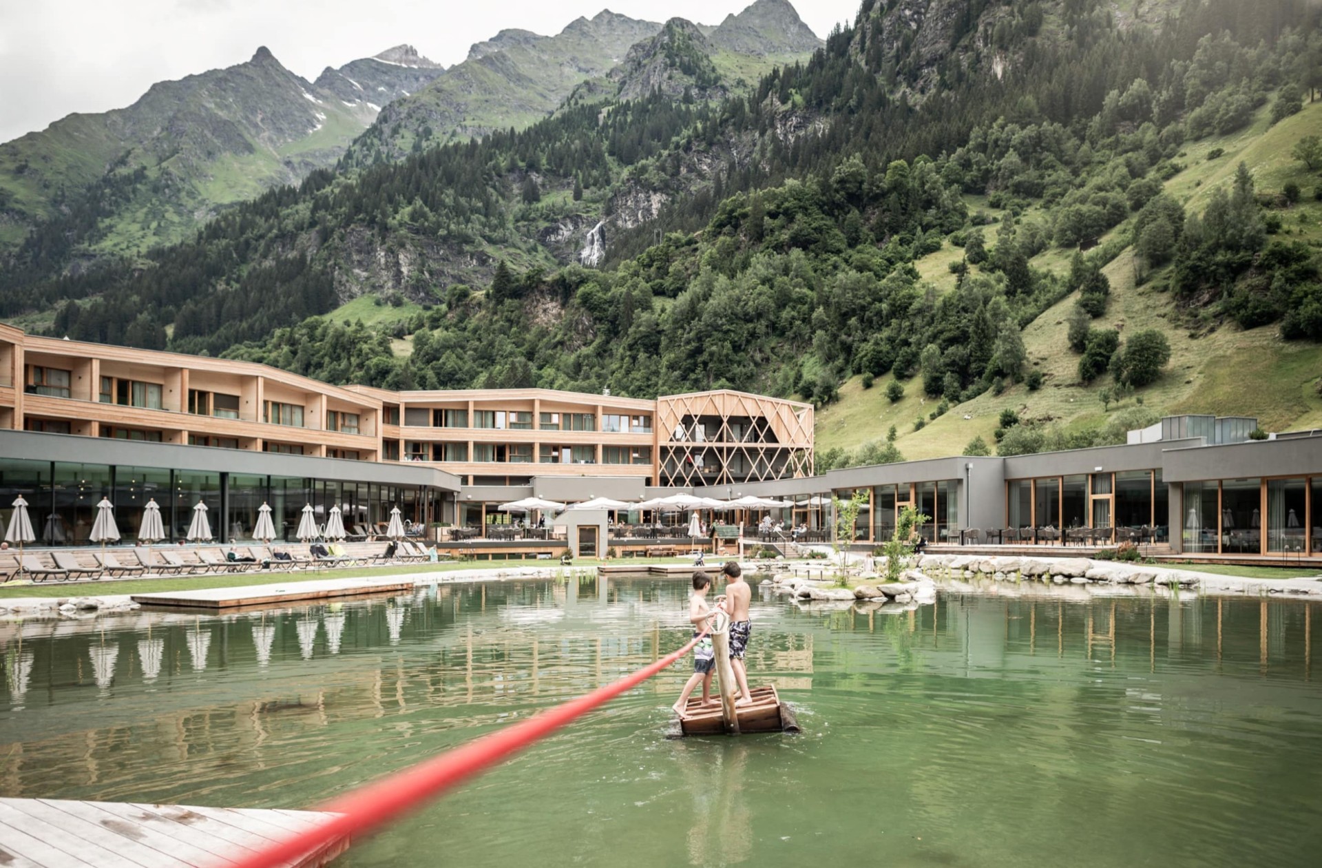 Kinder ziehen sich auf einem Floß über den See