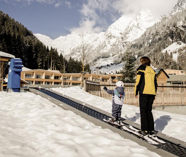 Kind mit Betreuer lernt Skifahren