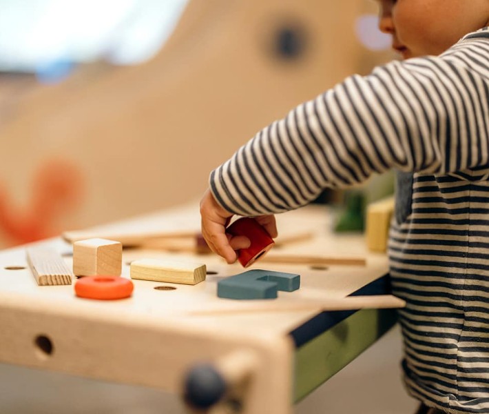 Kind spielt mit kleinen Holzklötzchen
