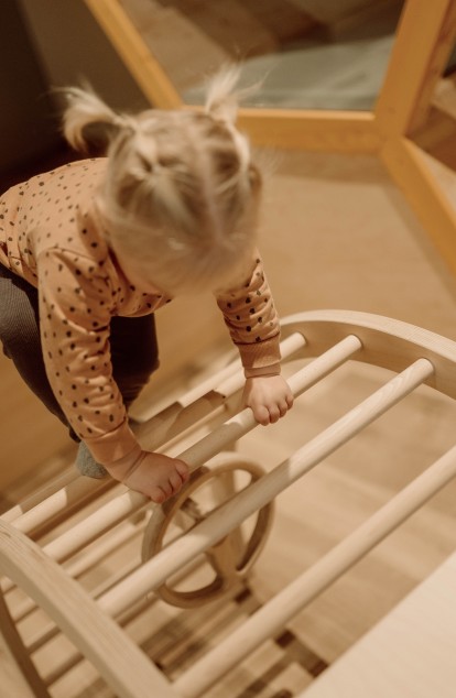 Ein Kinderbereich mit Holzspielzeug und einem kleinen Stuhl in warmen Farbtönen.