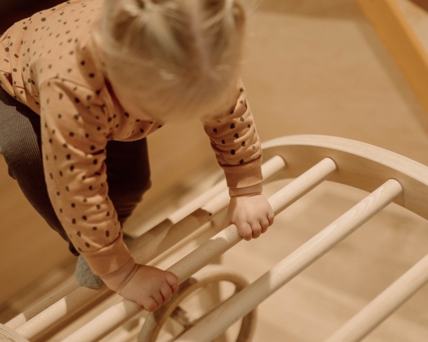Ein Kinderbereich mit Holzspielzeug und einem kleinen Stuhl in warmen Farbtönen.