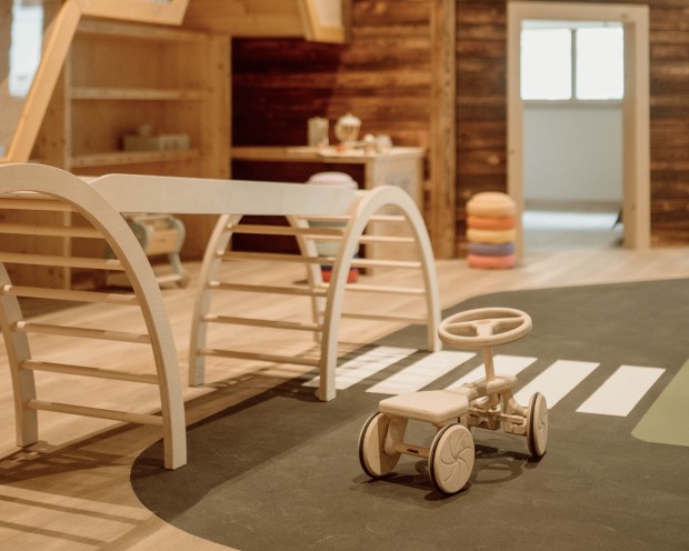 Ein Spielbereich mit einer Kletterstruktur und einem Fenster mit natürlichem Licht.