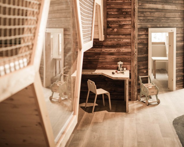 Ein märchenhafter Kinderbereich mit einer kleinen Holztreppe und beleuchteten Fenstern.