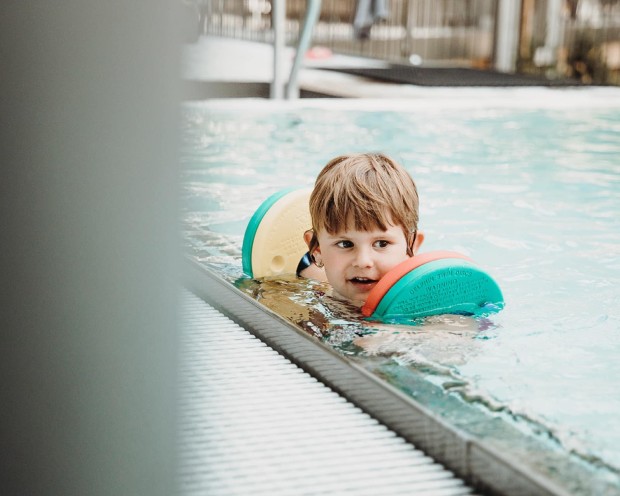 Schwimmen im Pool des Feuerstein, dem Kinderhotel mit Wasserrutsche in Südtirol