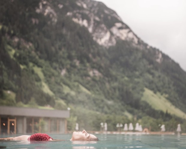 Sich treiben lassen im Outdoor Infinity Pool des Feuerstein, dem Kinderhotel mit Wasserrutsche in Südtirol
