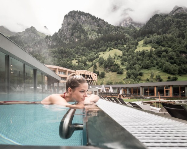 Entspannen im Outdoor Infinity Pool des Feuerstein, dem Kinderhotel mit Wasserrutsche in Südtirol
