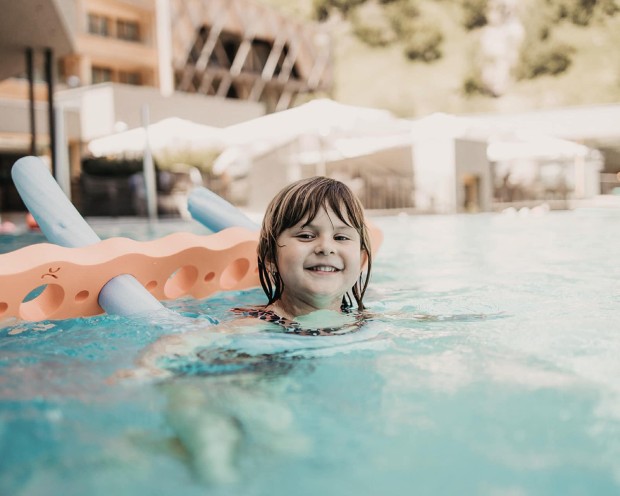 Schwimmen im Outdoor Infinity Pool des Feuerstein, dem Kinderhotel mit Wasserrutsche in Südtirol