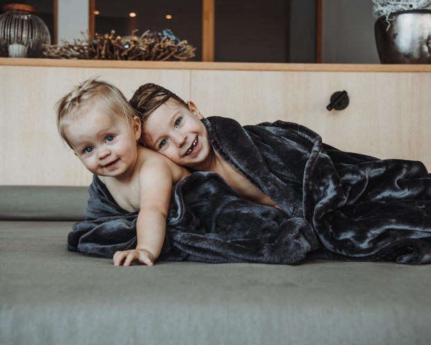 Kleine Kinder entspannen am Pool des Feuerstein, dem Kinderhotel mit Wasserrutsche in Südtirol