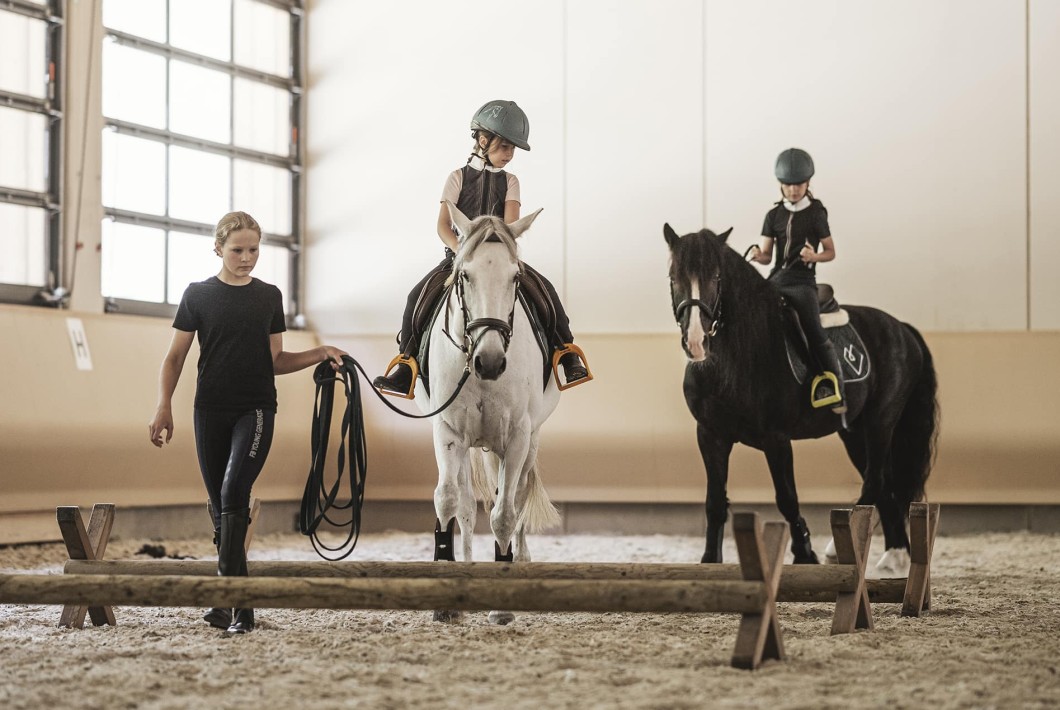 Reiten in der beheizten Reithalle während Ihrer Reitferien im Familienhotel Feuerstein in Südtirol