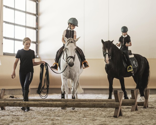 Reiten in der beheizten Reithalle während Ihrer Reitferien im Familienhotel Feuerstein in Südtirol