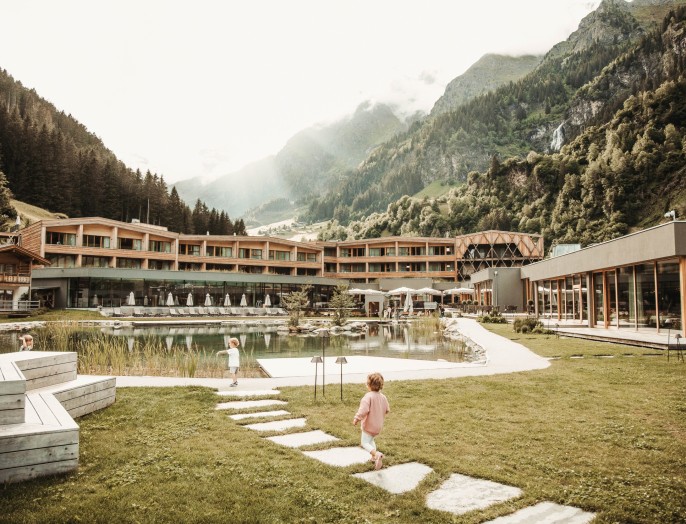 Kinder spazieren vor dem Teich des Hotels