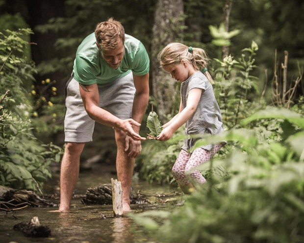 Familie im Wald in der Nähe vom Familienhotel Feuerstein, dem idealen Ort für Urlaub in den Bergen mit Kindern