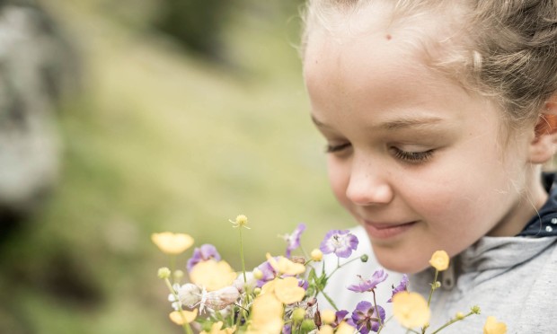Mädchen riecht an Blumen