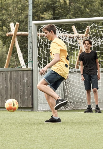 Teenager spielen Fußball auf dem Fußballplatz vom Hotel