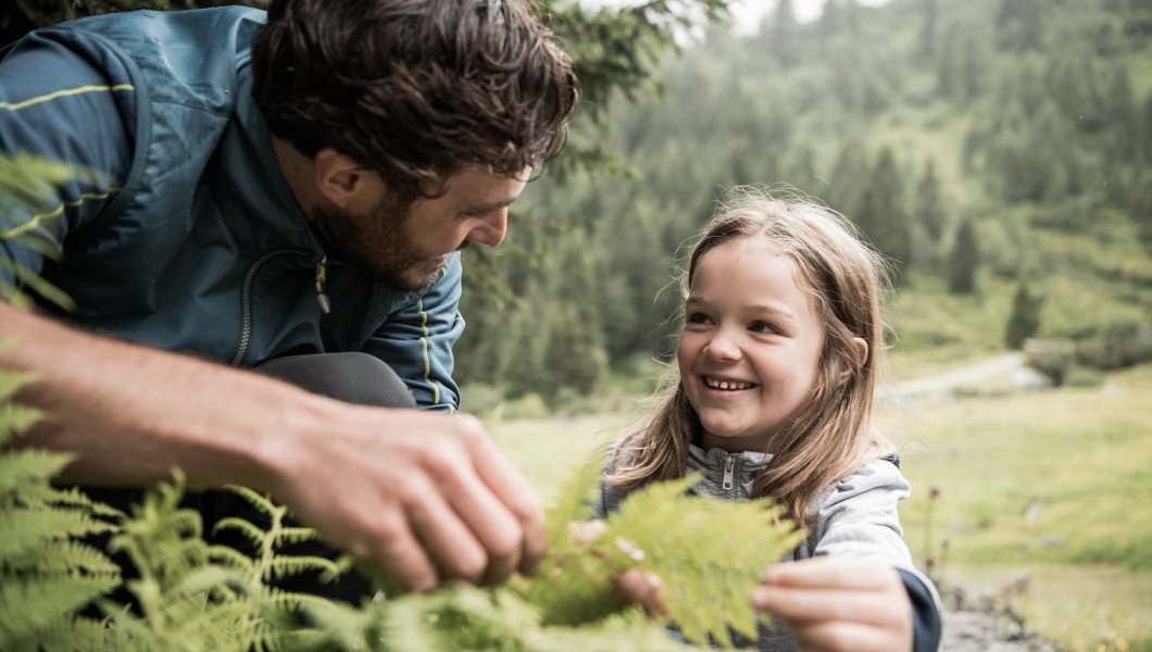 Kind und Vater begutachten eine Pflanze