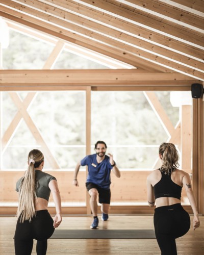 2 Frauen und 1 Mann machen Sport im Yoga Raum