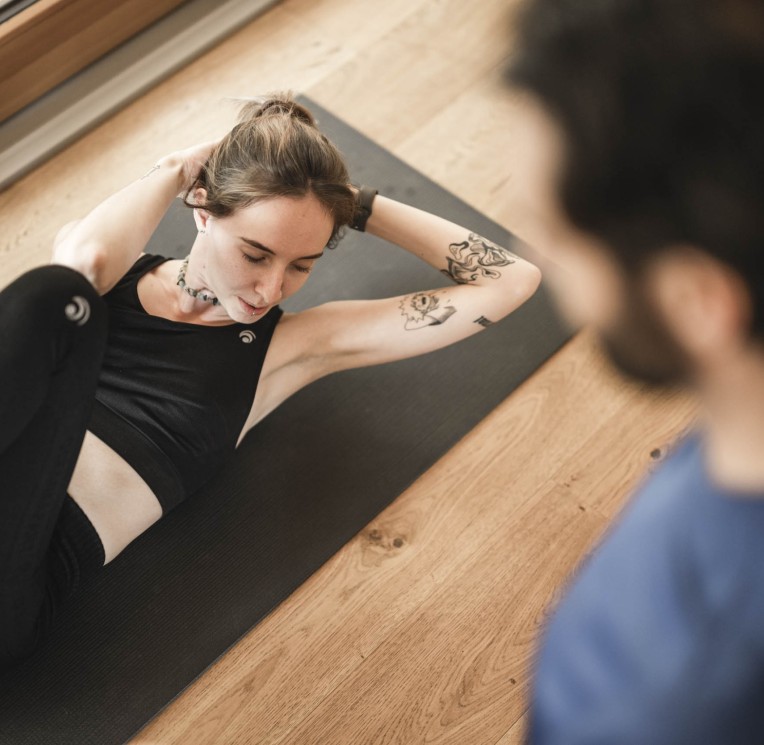 Frau macht Dehnübungen auf einer Yoga Matte