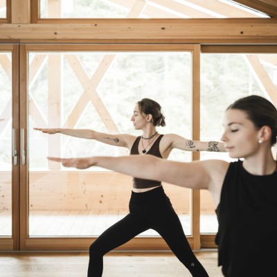 2 Frauen machen Yoga Übungen im Stehen im Yoga Raum