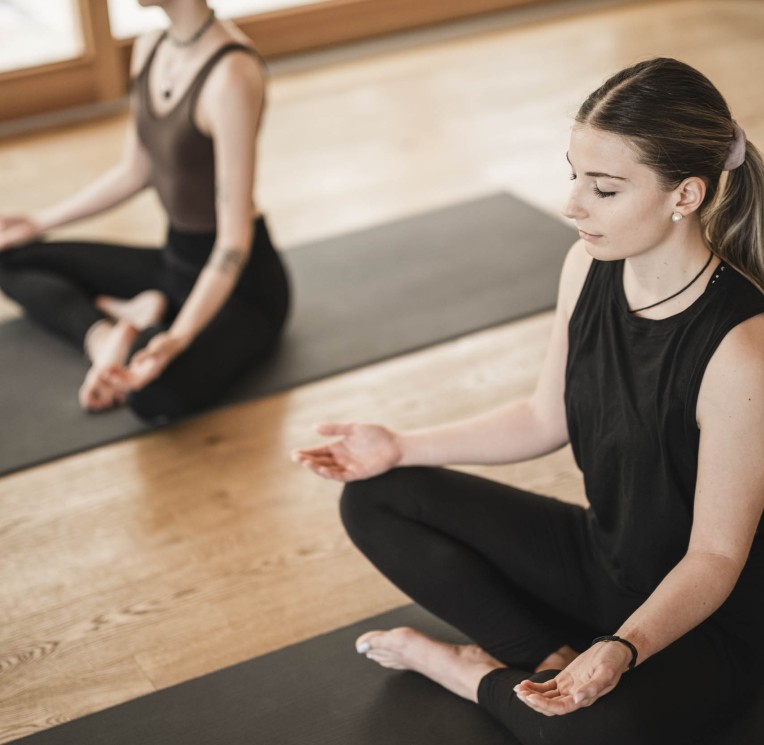 2 Frauen meditieren im Yoga Raum