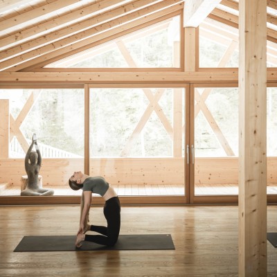 Frau macht Dehnübungen im Yoga-Raum