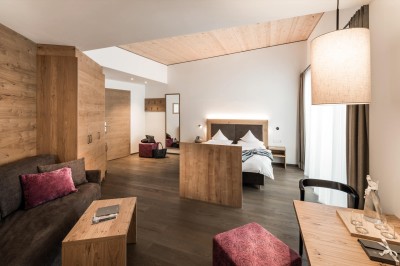 Doppelzimmer Dolomit mit Doppelbett, Couch und Schreibtsich