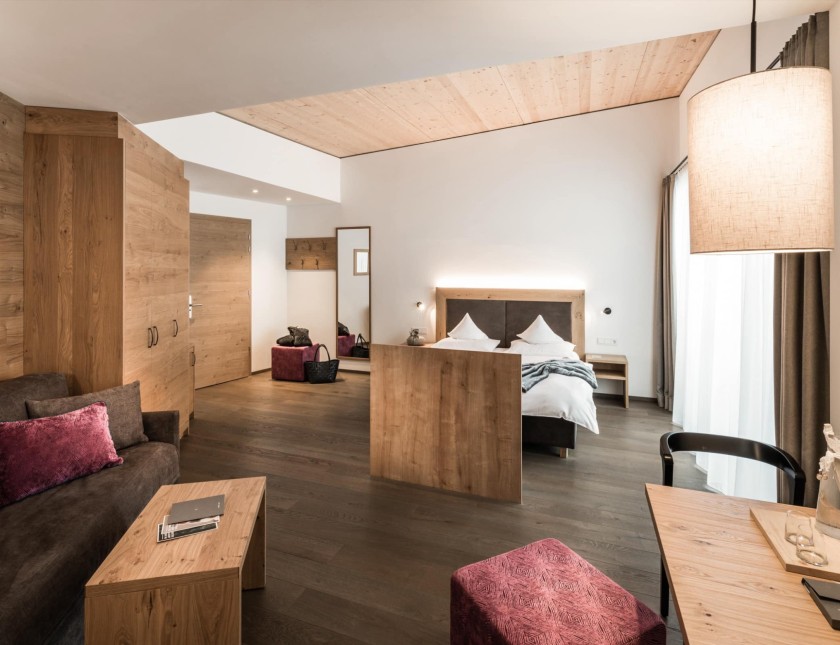 Doppelzimmer Dolomit mit Doppelbett, Couch und Schreibtsich
