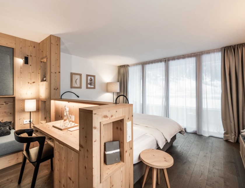Doppelzimmer Glimmer mit Schreibtisch und Doppelbett mit Sicht zum Balkon