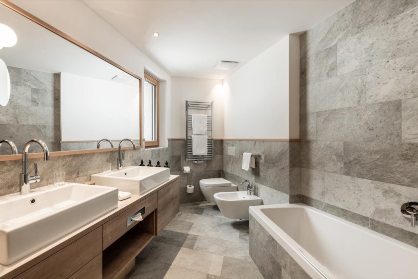 Doppelzimmer Dolomit Badezimmer mit Badewanne und Doppelwaschbecken