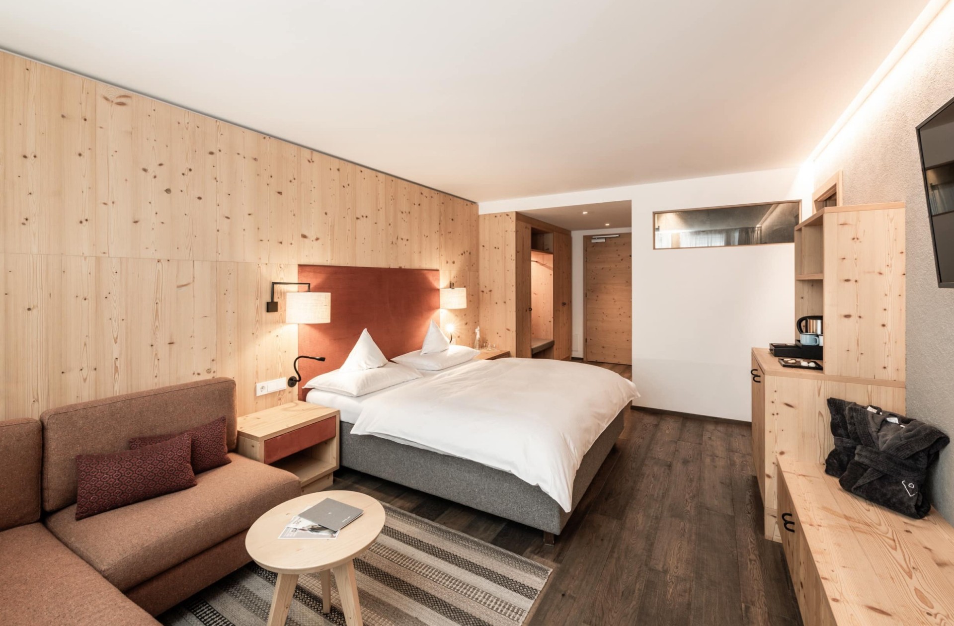 Doppelbett mit kleiner Couch und kleinem runden Tisch