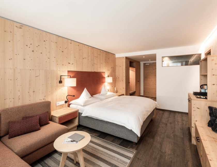 Doppelbett mit kleiner Couch und kleinem runden Tisch