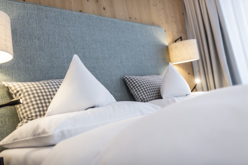 Doppelbett mit 2 Kissen und Lampen