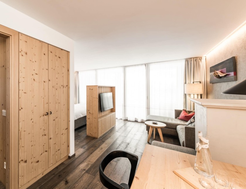 Zimmer mit Fernseher, Esstisch und Stockbett in einen anderen Raum