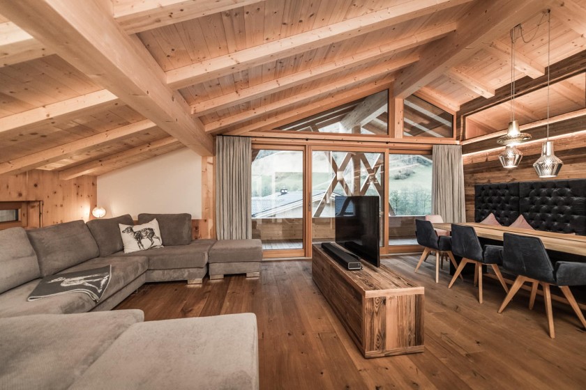 Große Couch und Fernseher mit Esstisch im Hintergrund