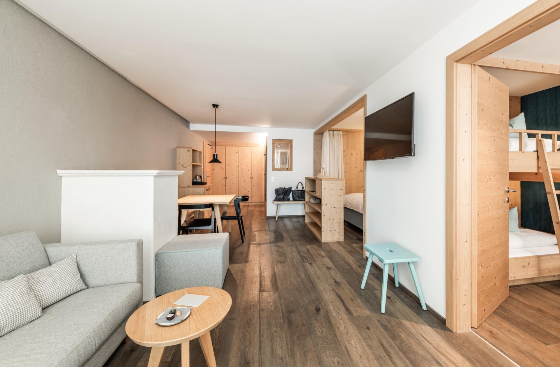 Familienzimmer Alpenjade mit Couch, Stockbett und Esstisch