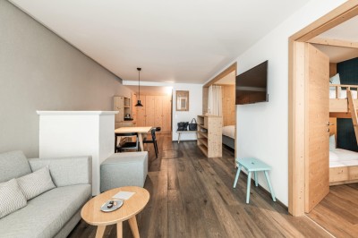 Familienzimmer Alpenjade mit Couch, Stockbett und Esstisch