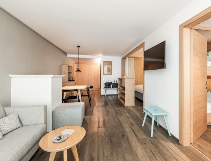 Familienzimmer Alpenjade mit Couch, Stockbett und Esstisch