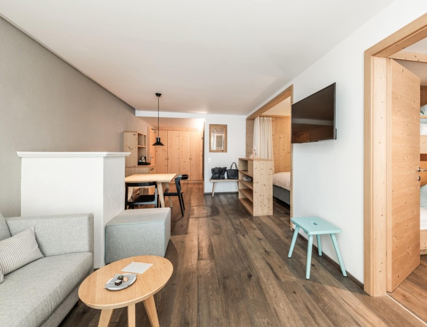 Familienzimmer Alpenjade mit Couch, Stockbett und Esstisch